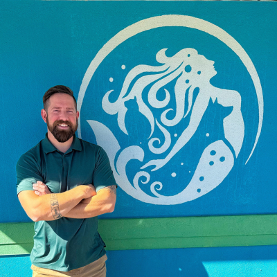 Tim team member wearing mask and holding dog